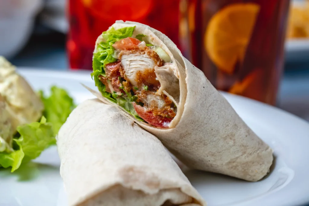side-view-chicken-roll-fried-chicken-strips-with-mayo-tomato-lettuce-wrapped-tortilla-scaled (1)